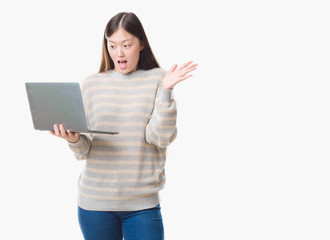 Young Chinese woman over isolated background using computer laptop very happy and excited, winner expression celebrating victory screaming with big smile and raised hands