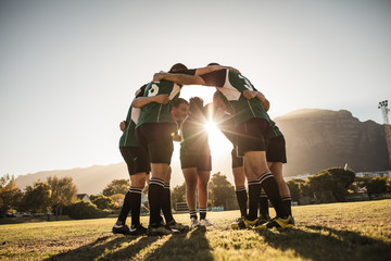Fototapeta Rugby players huddling on sports field obraz