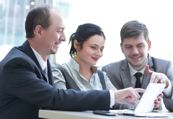 Business team using tablet touchpad for meeting to discuss statistical data.