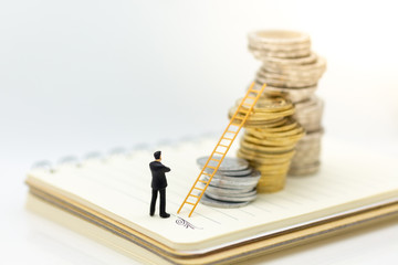 Miniature people: Businessman thinking and standing on stack of coins with stair. Image use for...