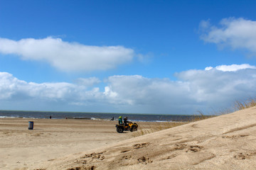 Personas andando en cuatriciclo, playa desierta 