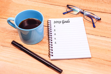 Coffee and notebook with goals for 2019