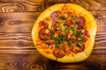 Fresh homemade pizza on a wooden table. Top view