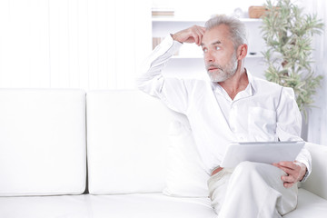 Fototapeta premium senior businessman with digital tablet sitting on sofa