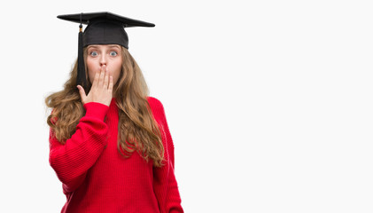 Young blonde woman wearing graduation cap cover mouth with hand shocked with shame for mistake, expression of fear, scared in silence, secret concept