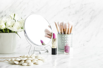 Feminine accessories on a marble dressing table.