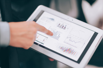 close up.businessmens discuss schedule of sales through the tab
