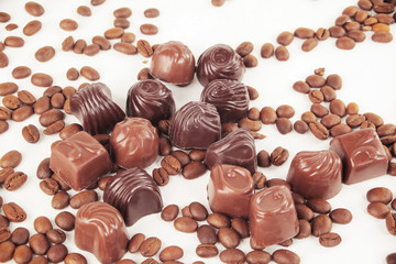 grain black coffee and chocolate candy on a white background