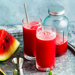 Freshly squeezed juice from a watermelon on a table in glasses. Preparation of a cocktail or a...