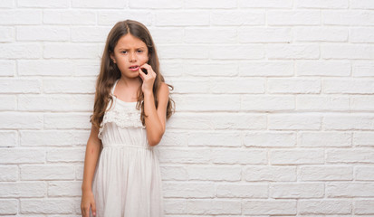 Young hispanic kid over white brick wall touching mouth with hand with painful expression because of toothache or dental illness on teeth. Dentist concept.