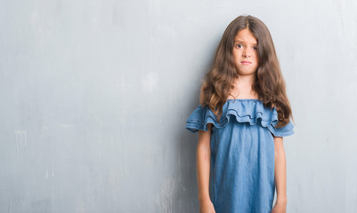 Fototapeta premium Young hispanic kid over grunge grey wall skeptic and nervous, frowning upset because of problem. Negative person.