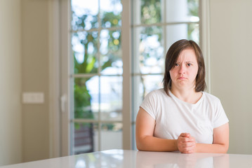 Down syndrome woman at home skeptic and nervous, frowning upset because of problem. Negative person.