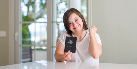Down syndrome woman at home holding australian passport screaming proud and celebrating victory and success very excited, cheering emotion