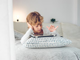 Cute boy with tablet on sofa