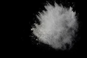 White powder explosion isolated on black background. Colored dust splatted.