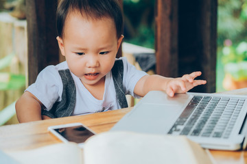 little boy learning with mobile phone, laptop, tablet, and book, family relation ship, home school education.