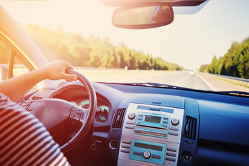 driver driving a car on asphalt road in summer day at park