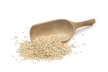 Overturned wooden spoon with quinoa seeds isolated on white background