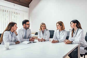 Medical team sitting and discussing at the table in the office.