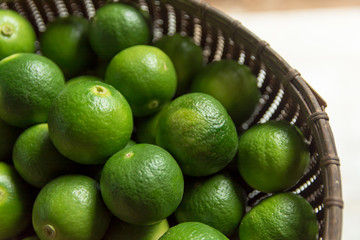 Lime Citrus Fruits in bamboo basket background. Fresh juicy limes. Healthy food