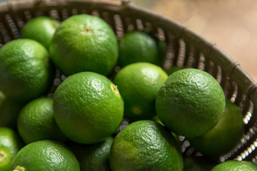 Lime Citrus Fruits in bamboo basket background. Fresh juicy limes. Healthy food