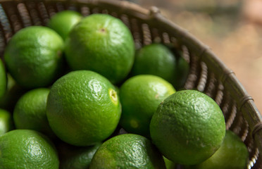 Lime Citrus Fruits in bamboo basket background. Fresh juicy limes. Healthy food