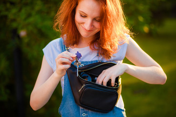 Red-haired girl pulls out of her waist bag