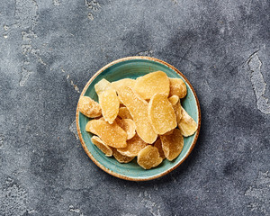Dried sweet ginger with sugar on a gray table. Top view.