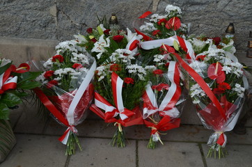 Biało-czerwone wiązanki złożone pod pomnikiem, polska symbolika - obrazy, fototapety, plakaty