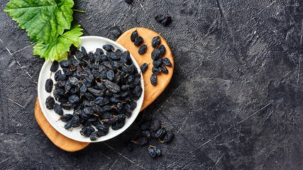 Black raisins on plate. Top view of dried grapes.