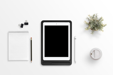 Tablet with blank screen for mockup on black case on white office desk. Notepad, pencil, clips,...