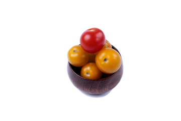 Isolated red and yellow cherry tomatoes in a wooden bowl