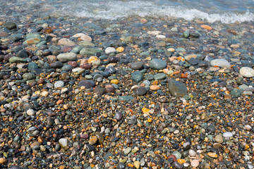 Coloured pebble ashore sea.