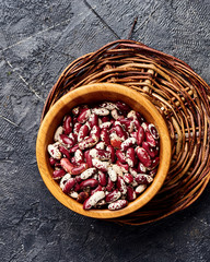 Red beans with white spots on black background. Top view.