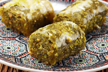 Turkish Dessert fıstık ezmesi baklava with pistachio on wooden table.