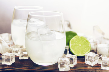 Drink with ice in a glass beaker with a lime slice
