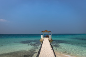 A small hut gazebo surrounded by tropical beach in Maldives.