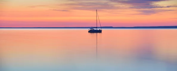 Fototapete See / Teich Die Welt in Ruhe - Segelboot im ruhigen See bei Sonnenuntergang