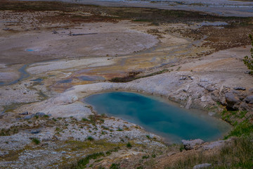 Pools of colorfully colored water dot the landscape of the Norris Geyser Basin in Yellowstone National Park.