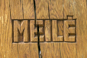 Meile, love in Lithuanian language carved on a wooden table broken in the middle