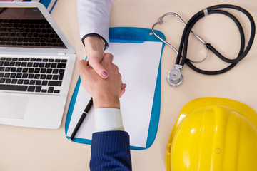 Doctor and manager agreeing industrial insurance coverage