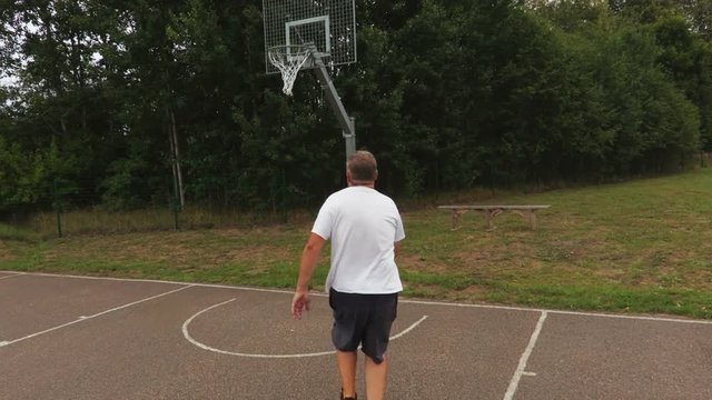 The camera follows a man who can not throw in a basket
