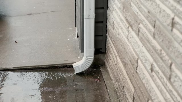 Rain running out of gutter downspout during rain storm