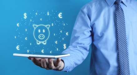 Man holding piggy bank with currency symbols. Investment concept