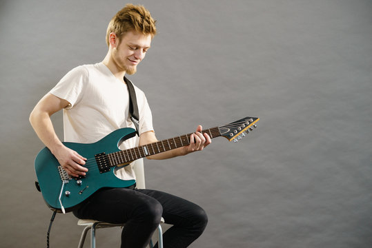 Young man playing electric guitar