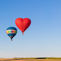 Red heart shaped and colorful air balloons flying in the sky, banner