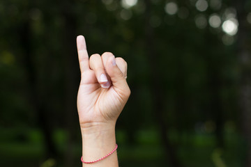 signs and symbols for people with disabilities mute and deaf humans concept of dactyl alphabet by female hand and fingers with empty space for copy or text on unfocused dark background