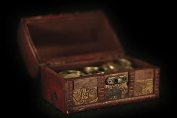 trunk with coins on a perfectly black background
