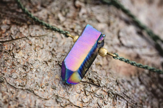 Crystal quartz pendant necklace detail on wooden background