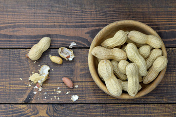 Peanuts in wooden bowl, top view